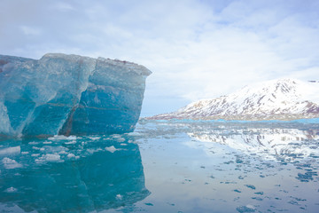 Blue iceberg and mountain reflection