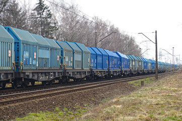 Fototapeta na wymiar All wagons in shades of blue. Long freight train.