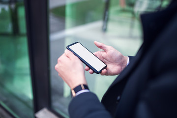 man hand holding modern black smartphone indoor