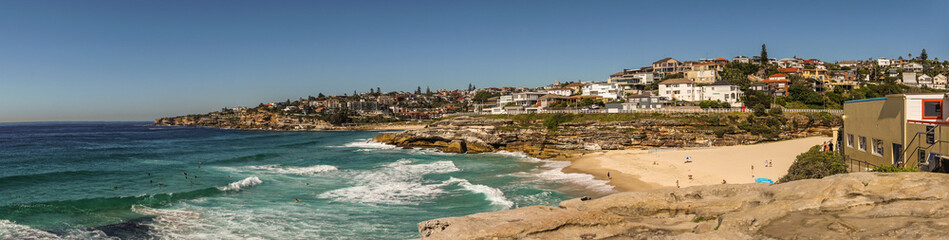 Sydney, Australia - February 11, 2019: Panorama shot of sandy Tamarama beach in front and Bronte...