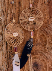 Dreamcatcher with feather on the wooden background