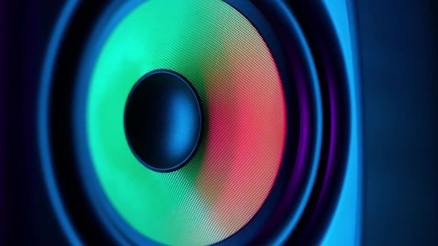 Macro close up of vibrating loud sound speaker in colorful neon lighting