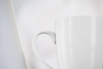 White cup isolated on white blurred background.