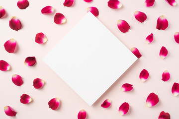 top view of red rose petal with white square card