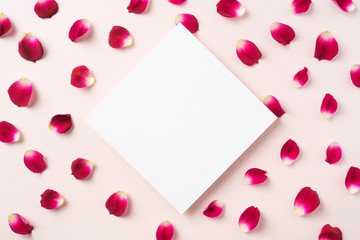 top view of red rose petal with white square card