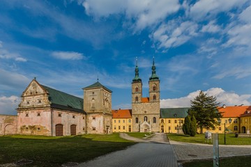 Tepla, Czech Republic / Europe - April 3 2019: Premonstratensian monastery founded in 12th century by Blessed Hroznata, abbey church made of stone with two towers, sunny day, blue sky, green grass