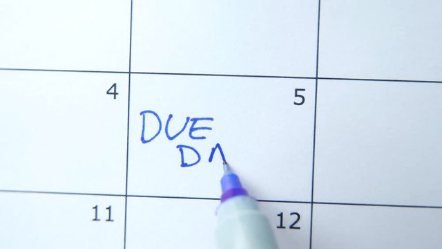 Closeup on a calendar with DUE DATE being marked by a marker