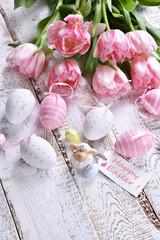 easter decoration with painted eggs and pink tulips