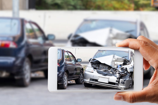 Car insurance agents take pictures of accident-damaged with smartphone for insurance claim