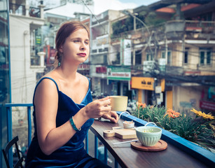 Beautiful woman enjoying tea on cafe terrace