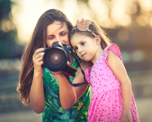 Mother and daughter taking photos with camera