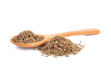 dried cumin seed or caraway in wooden spoon isolated on white background