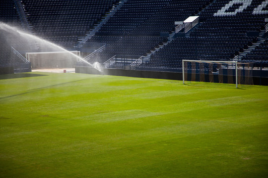 Water Jets Sprinkling A Football Stadium.