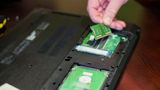 Man uninstalling memory. Laptop RAM upgrade