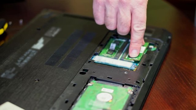 Man installing memory. Laptop RAM upgrade