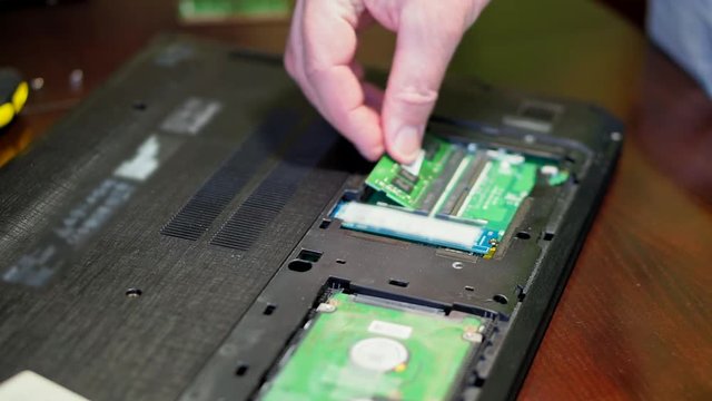 Man installing memory. Laptop RAM upgrade