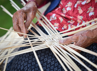 Old senior woman hand working crafts weaving bamboo making basket for nature product in Thailand Asia