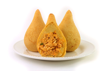 Coxinha in the dish, traditional snacks of Brazilian cuisine stuffed with chicken, isolated on white background