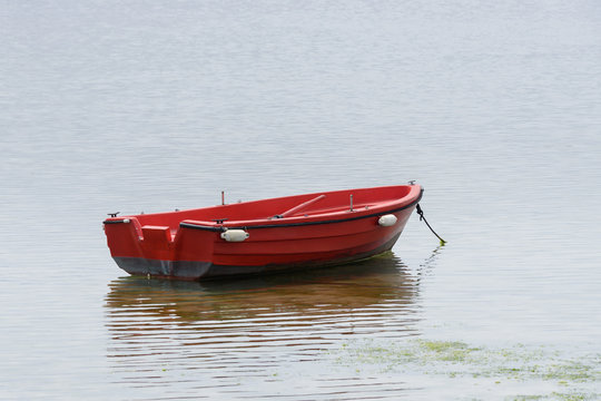 Red Wooden Fishing Boat Moored At The Sea