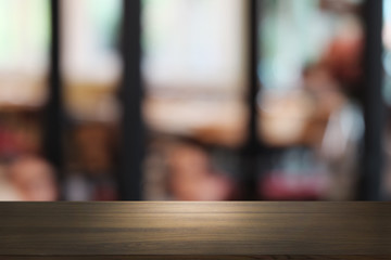 Empty dark wooden table in front of abstract blurred bokeh background of restaurant . can be used for display or montage your products.Mock up for space.