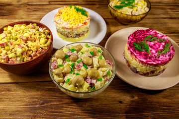 Set of festive mayonnaise salads on wooden table