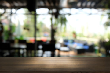 Empty dark wooden table in front of abstract blurred bokeh background of restaurant . can be used for display or montage your products.Mock up for space.