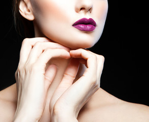 Obraz na płótnie Canvas Part of beauty fashion model woman studio portrait, bright purple lips make-up, clean skin, hands near neck. Black background