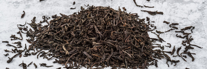 Dried tea is piled on a marble table.