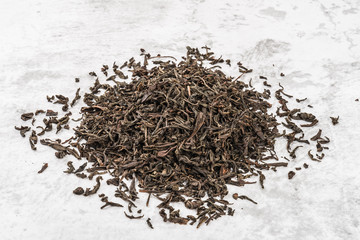 Dried tea is piled on a marble table.