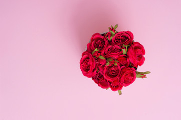 Beautiful red roses in a round box. Roses in a round box on a pink background. Roses in a Hat Box