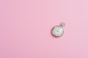 Analogue metal stopwatch on the pink background