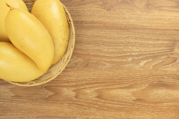 Fresh mango top view. wooden background and copy space for add text.