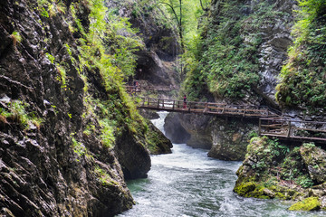 Young undefined girl walking on wooden bridge  at Vintgar Gorge canyon. Slovenia