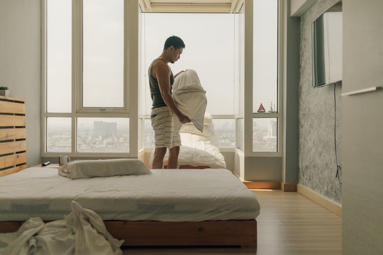 Asian Man Is Cleaning His Bedroom With Warm Summer Light.