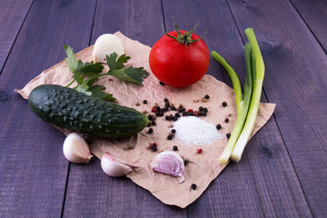 Vegetables on crumpled paper on wooden rustic background, closeup.