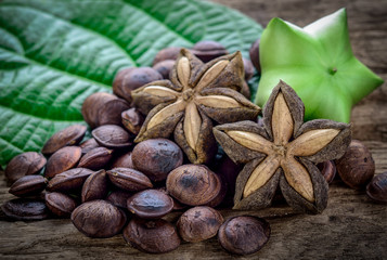 Fototapeta na wymiar dried capsule seeds fruit of sacha-Inchi peanut on wooden table