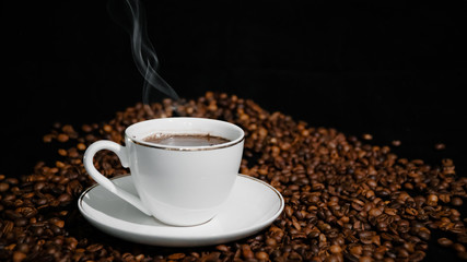 Cup with hot coffee and steam on a dark background