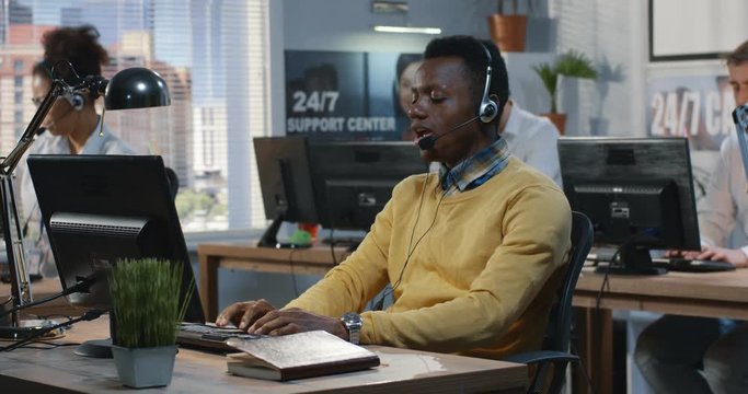 Confident young man working at a call center