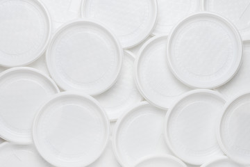 White disposable plastic tableware. Plastic plates. Abstract background of clean white dishes.