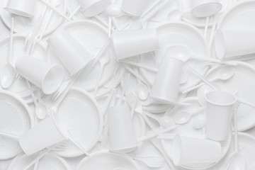 White disposable plastic tableware. Plastic plates, сups, forks, spoons, knives. Abstract...