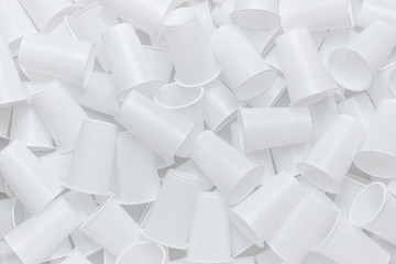 The texture of randomly scattered white disposable plastic cups. Abstract background of plastic...