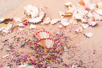 Colorful pencil shavings on brown background