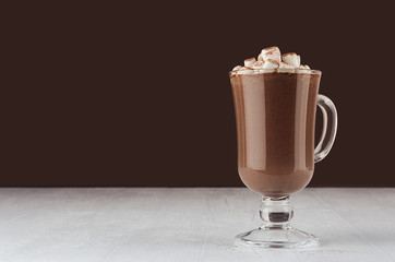 Christmas beverage - hot chocolate in mug with marshmallows, cocoa powder  in elegant dark brown interior, copy space.