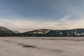 Early spring evening landscape of frozen Little Shuswap Lake British Columbia Canada.