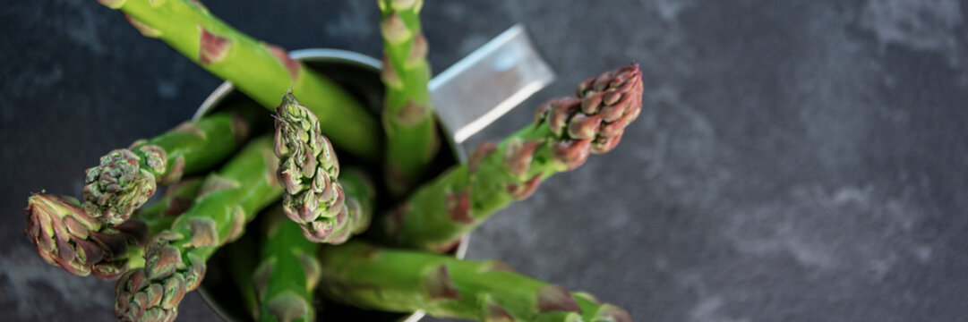 asparagus in mug on grey tabale panorama