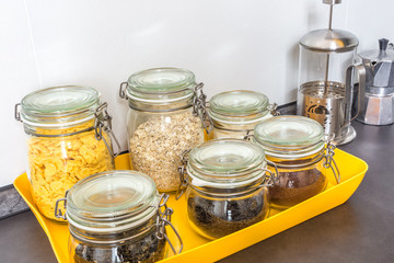 glass stylish vintage jars with different food in the kitchen. Oatmeal, cornflakes, coffee tea