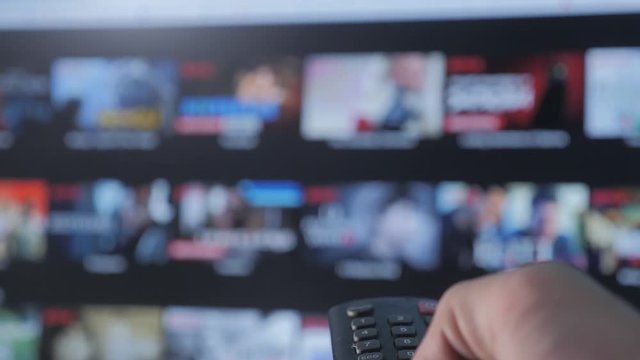 smart tv. online video streaming service. with apps and hand lifestyle . Male hand holding remote the control turn off smart tv. man hand controls holding remote. concept internet online cinema