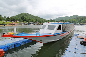 Fototapeta na wymiar Thai boat floating on river and bungalows floating on river at kanchanaburi, Thailand.