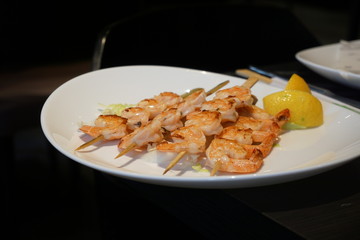 Grilled tiger shrimps skewers with lemon