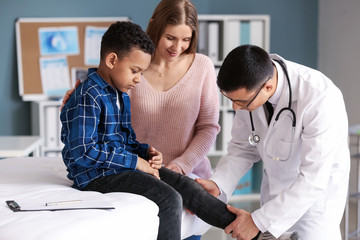 Obraz premium Pediatrician examining African-American boy in clinic